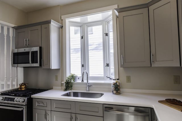 kitchen with stainless steel appliances, gray cabinets, and sink