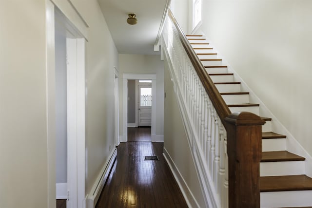 staircase with hardwood / wood-style flooring and a baseboard radiator