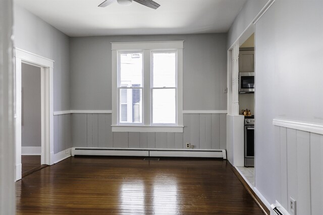 spare room with ceiling fan, dark wood-type flooring, and baseboard heating