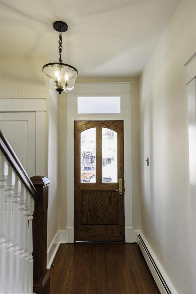 entrance foyer with dark hardwood / wood-style flooring, a baseboard heating unit, and a chandelier