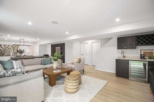 living room featuring wine cooler, wet bar, and light wood-type flooring