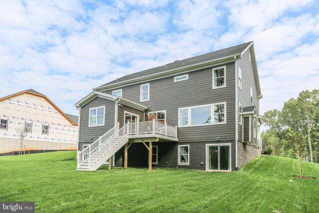 rear view of house with a deck and a lawn