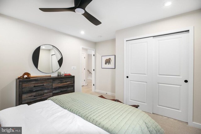 carpeted bedroom with a closet and ceiling fan