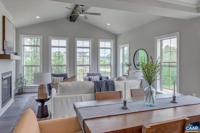 sunroom featuring lofted ceiling with beams, a large fireplace, and ceiling fan