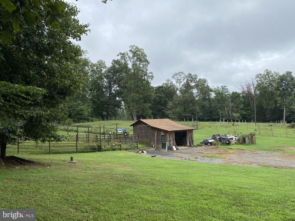 exterior space featuring an outbuilding, a rural view, and fence