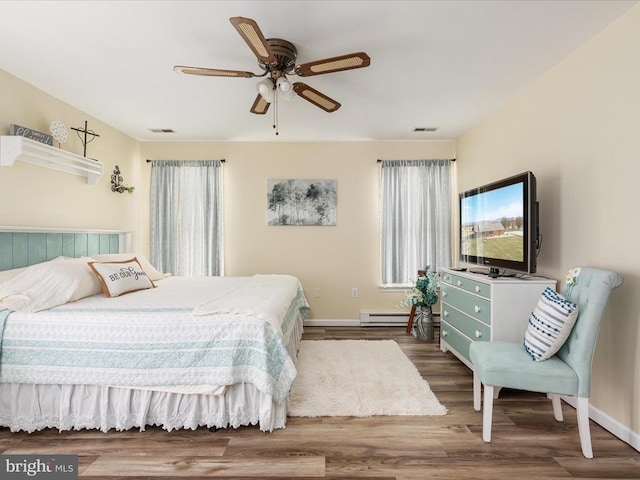 bedroom featuring hardwood / wood-style flooring, ceiling fan, and baseboard heating