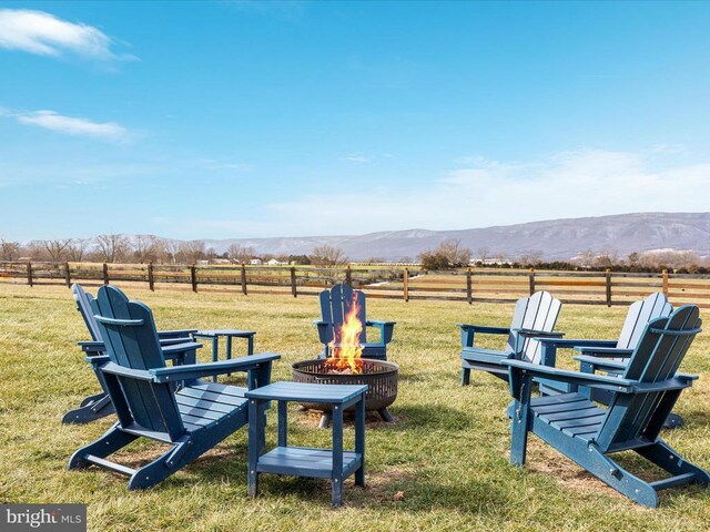 view of yard featuring a rural view, a mountain view, and an outdoor fire pit