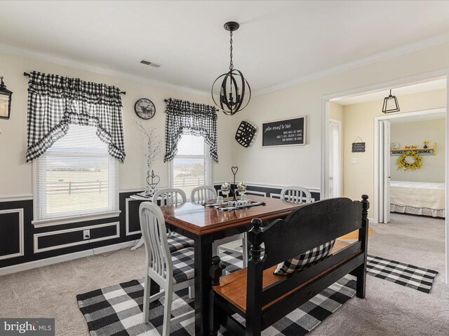 dining space featuring an inviting chandelier, light colored carpet, and ornamental molding