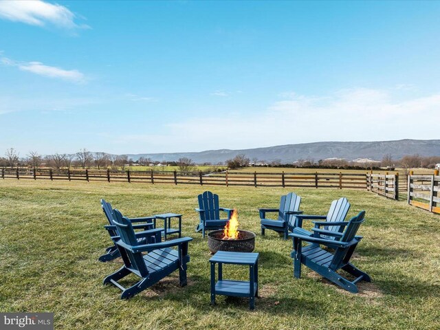 view of yard with a mountain view, a rural view, and a fire pit