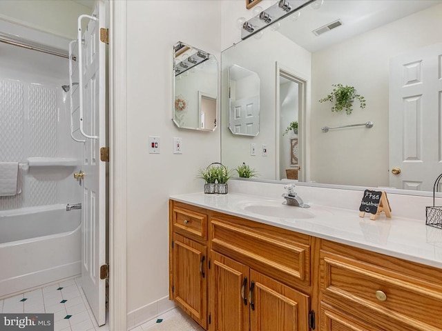 bathroom featuring tile patterned flooring, vanity, and  shower combination