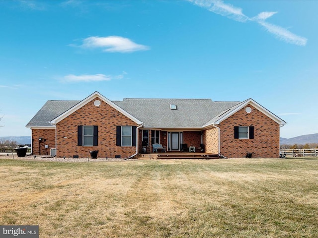 ranch-style home featuring a deck and a front lawn