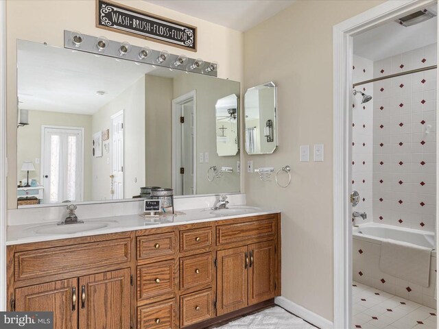 bathroom with tiled shower / bath and vanity