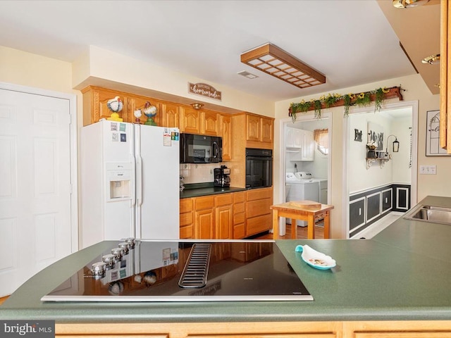 kitchen with sink, black appliances, and independent washer and dryer