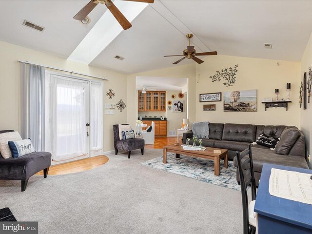 living room featuring ceiling fan, lofted ceiling, and carpet flooring