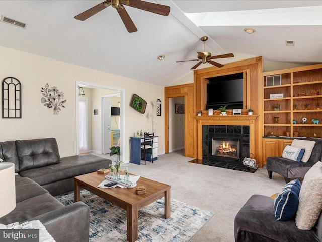 carpeted living room featuring ceiling fan, a fireplace, and lofted ceiling with beams