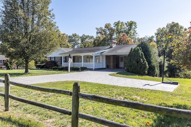 ranch-style house with covered porch and a front lawn