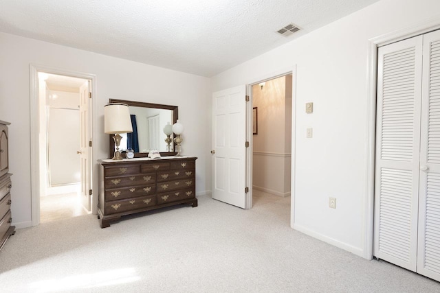 carpeted bedroom with a closet and a textured ceiling