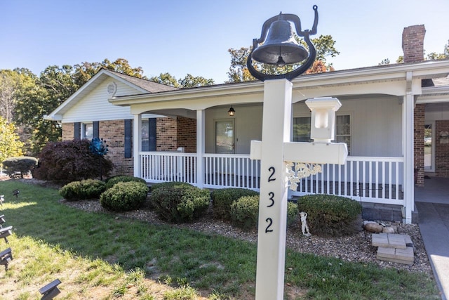 view of front of house with a porch and a front yard