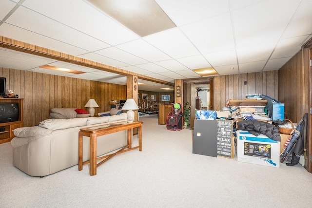 interior space featuring a paneled ceiling and wooden walls