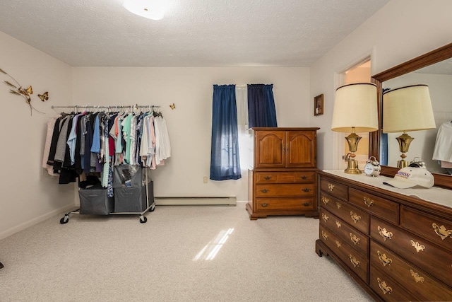 carpeted bedroom featuring a textured ceiling and a baseboard heating unit