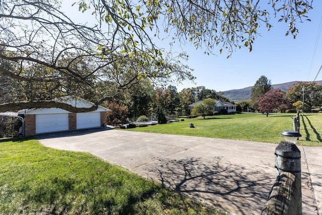 view of front facade featuring a mountain view, a garage, and a front yard