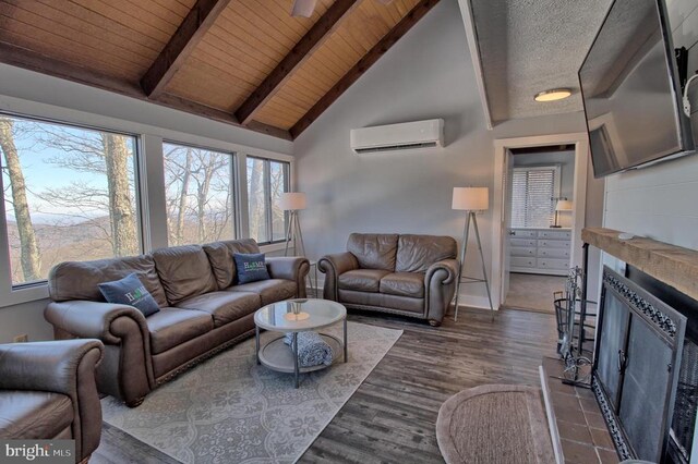 living room featuring a wall mounted air conditioner, a fireplace, beamed ceiling, and plenty of natural light