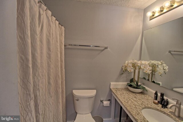 bathroom featuring sink, toilet, and a textured ceiling