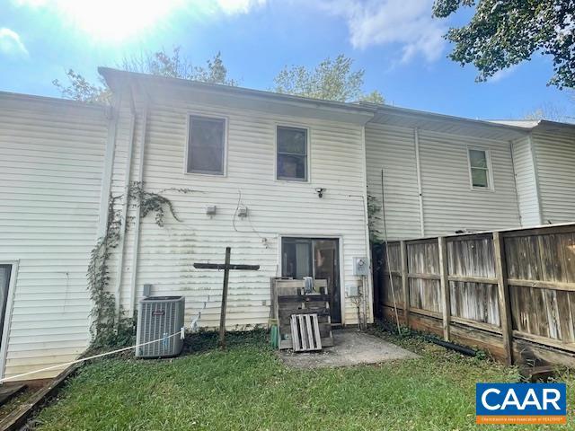 rear view of house with cooling unit, a yard, and a patio area