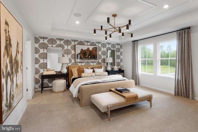 carpeted bedroom featuring an inviting chandelier and a tray ceiling