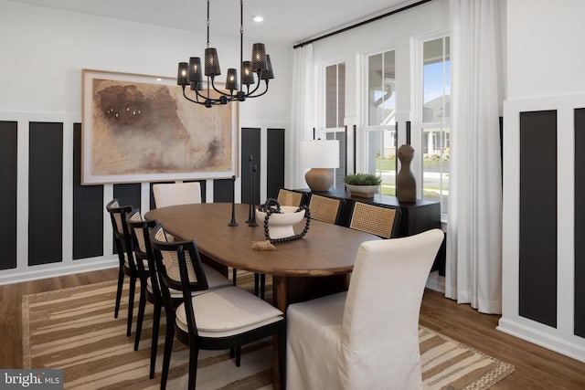 dining space with hardwood / wood-style flooring and an inviting chandelier