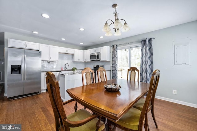 dining area featuring dark wood-type flooring, recessed lighting, a chandelier, and baseboards