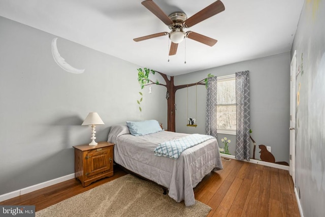 bedroom featuring ceiling fan, baseboards, and wood finished floors