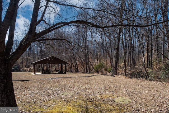 view of yard featuring a forest view and a gazebo