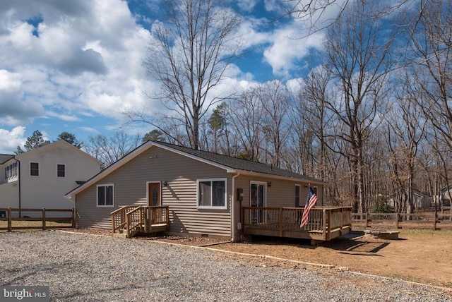 view of front of property featuring crawl space, driveway, fence, and a wooden deck