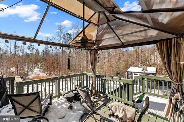 snow covered deck with an outbuilding