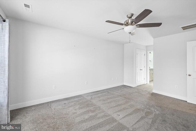 carpeted spare room featuring ceiling fan