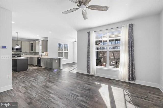 unfurnished living room featuring ceiling fan, dark hardwood / wood-style floors, and sink