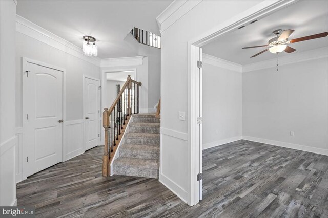 interior space with ornamental molding, dark wood-type flooring, and ceiling fan