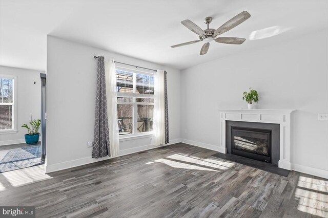 unfurnished living room with dark hardwood / wood-style floors and ceiling fan