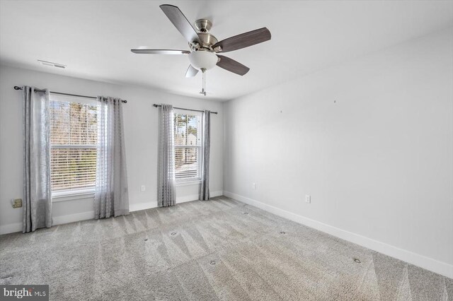 carpeted spare room with ceiling fan