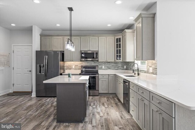 kitchen with pendant lighting, sink, gray cabinetry, a center island, and stainless steel appliances