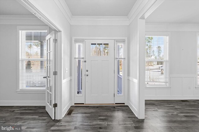 entrance foyer with ornamental molding and dark hardwood / wood-style floors