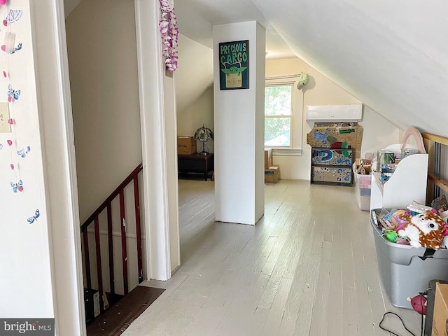 bonus room featuring lofted ceiling, wood-type flooring, and an AC wall unit