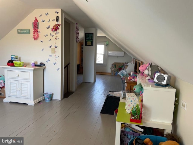 bonus room featuring wood-type flooring, vaulted ceiling, and an AC wall unit