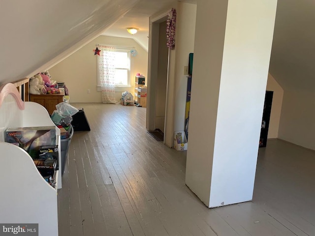 additional living space featuring hardwood / wood-style flooring and vaulted ceiling