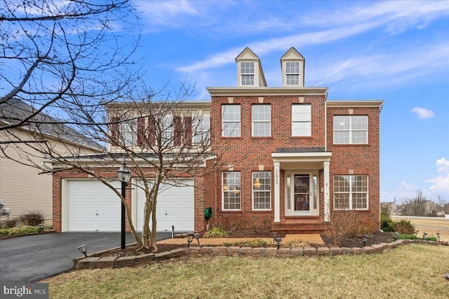 view of front of house featuring a garage, driveway, brick siding, and a front yard