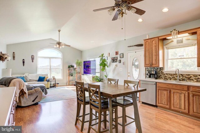 dining room featuring ceiling fan, lofted ceiling, light hardwood / wood-style floors, and sink