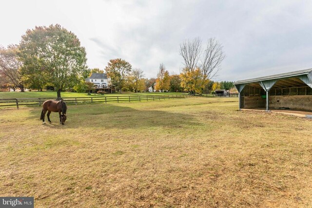 view of yard with a rural view and an outbuilding