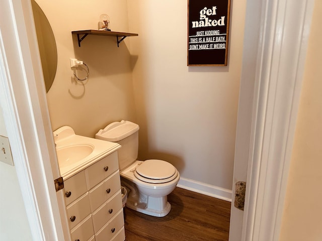 bathroom with vanity, wood finished floors, toilet, and baseboards