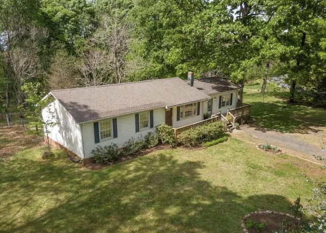 single story home with a front yard, driveway, and a chimney